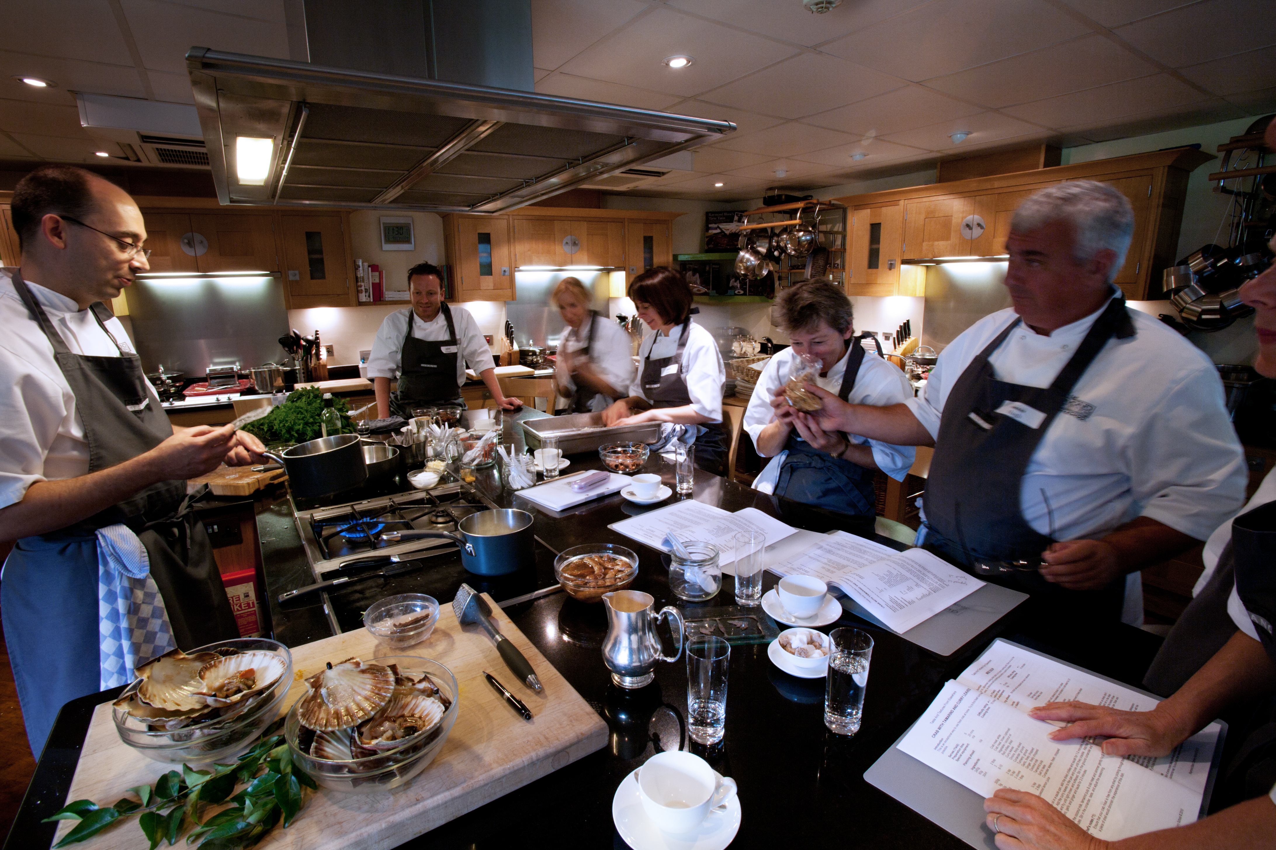 Fresh ingredients, recipe notes and cooking utensils arranged for a culinary lesson